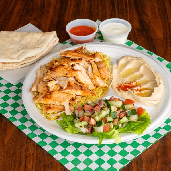 Leyla's Mediterranean Cafe chicken shawarma plate with rice, salad, hummus, pita, and sauces.
