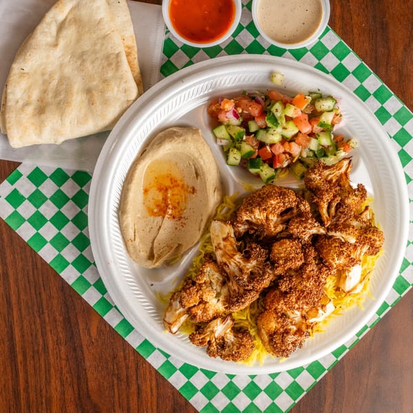 Leyla's Mediterranean Cafe platter with roasted cauliflower, rice, hummus, salad, pita, and sauces.