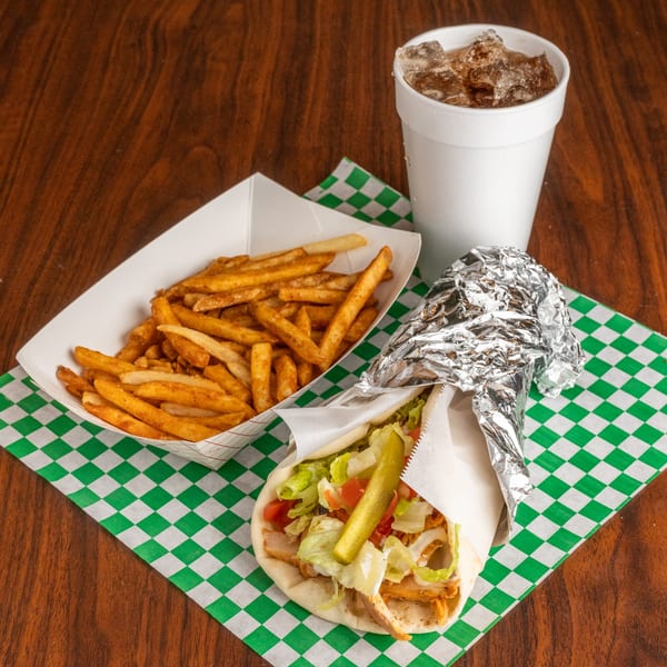 Leyla's Mediterranean Cafe chicken shawarma wrap with fries and a soda on a checkered napkin.