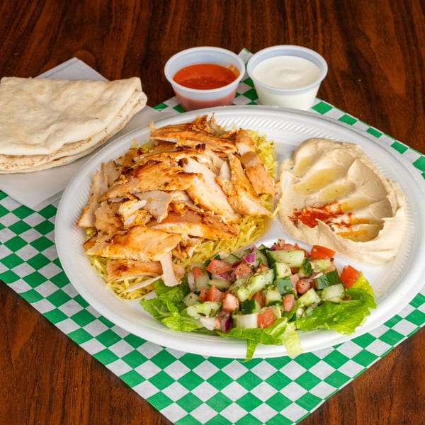 Leyla's Mediterranean Cafe chicken shawarma plate with rice, hummus, salad, pita, and sauces.